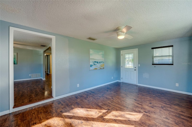 unfurnished room featuring a textured ceiling, ceiling fan, and dark wood-type flooring