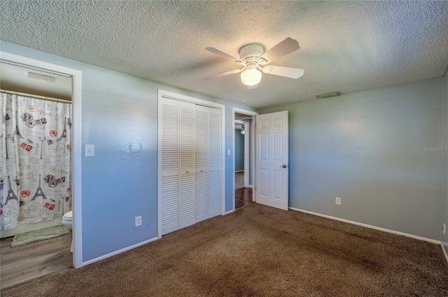 unfurnished bedroom with ceiling fan, ensuite bathroom, carpet floors, a textured ceiling, and a closet