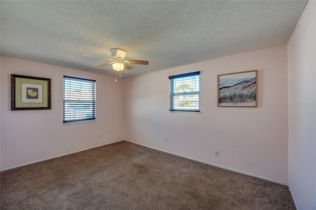 carpeted empty room featuring ceiling fan and a textured ceiling