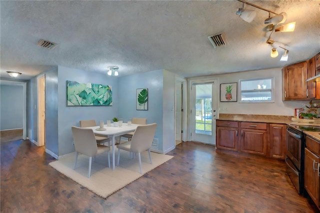 dining space with dark hardwood / wood-style floors and a textured ceiling