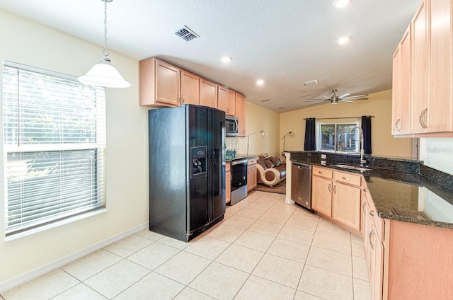 kitchen featuring kitchen peninsula, appliances with stainless steel finishes, vaulted ceiling, sink, and decorative light fixtures