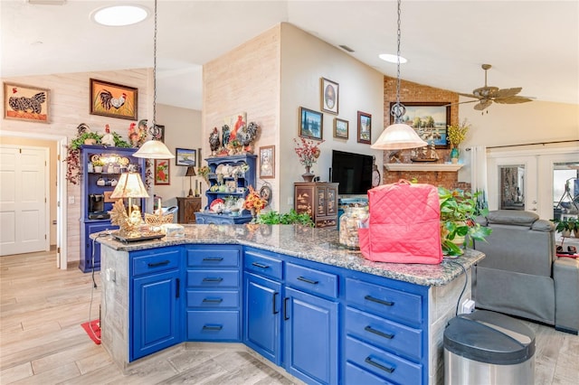 kitchen featuring blue cabinetry, pendant lighting, and lofted ceiling