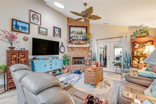 living room with ceiling fan, french doors, vaulted ceiling, and light wood-type flooring