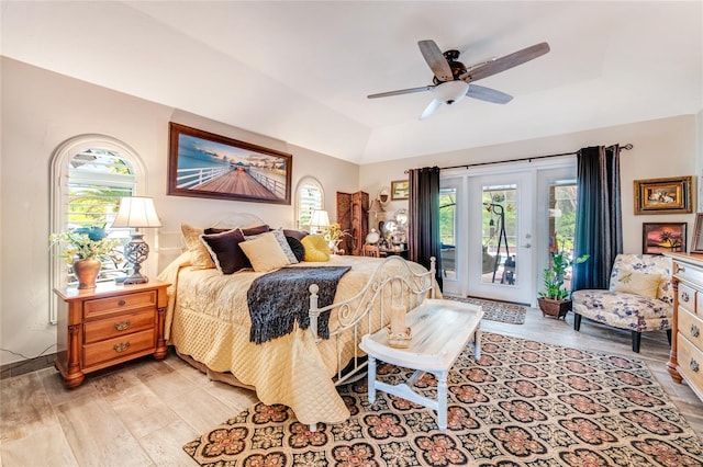 bedroom with a raised ceiling, light hardwood / wood-style flooring, and ceiling fan