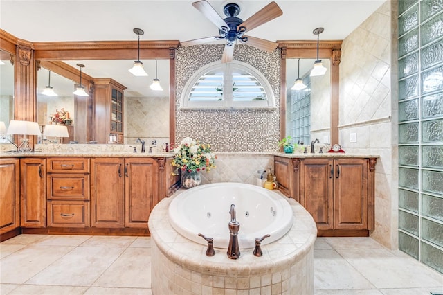 bathroom with tiled tub, ceiling fan, vanity, and tile walls