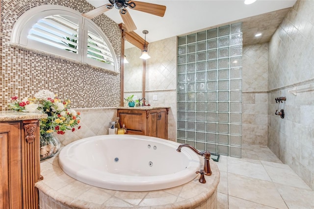 bathroom featuring plus walk in shower, vanity, tile walls, and ceiling fan