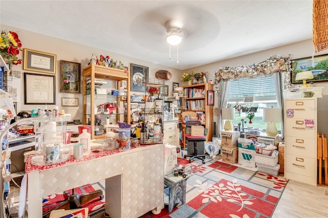 home office with ceiling fan and light hardwood / wood-style flooring