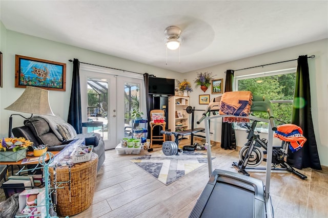 workout room with ceiling fan, french doors, plenty of natural light, and light wood-type flooring