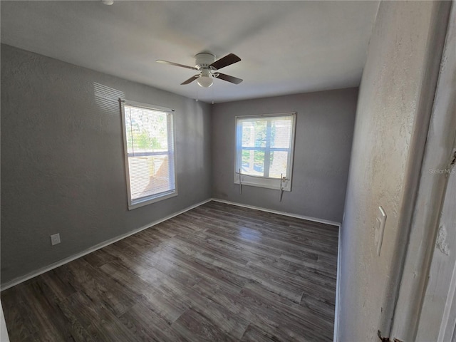 spare room with ceiling fan and dark wood-type flooring