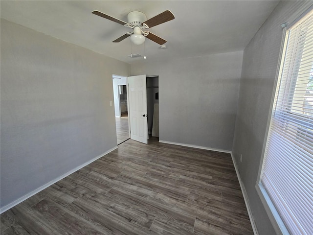 spare room featuring ceiling fan and dark wood-type flooring