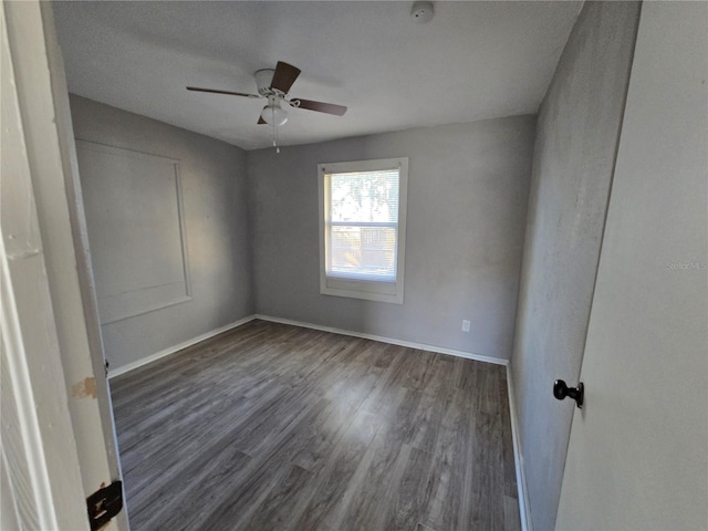 empty room with dark hardwood / wood-style flooring and ceiling fan