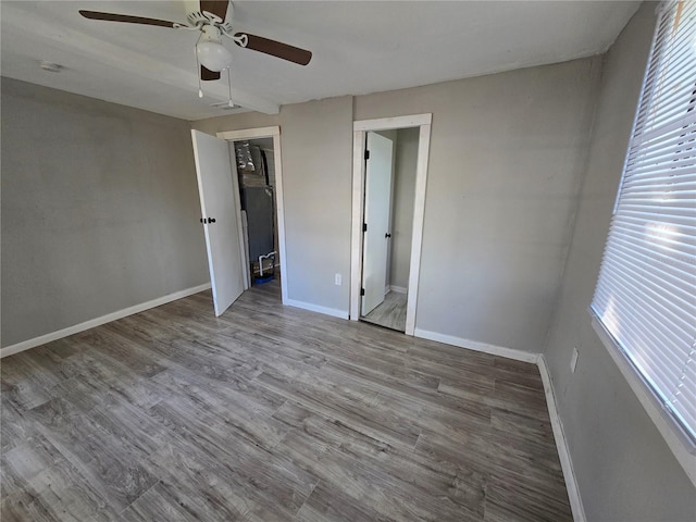 unfurnished bedroom featuring ceiling fan, a closet, and hardwood / wood-style flooring