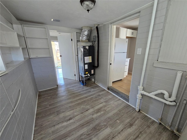 interior space with hardwood / wood-style flooring and heating unit