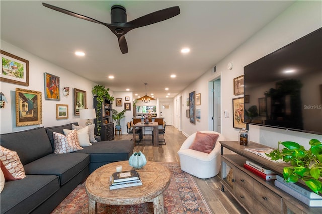 living room featuring wood-type flooring and ceiling fan