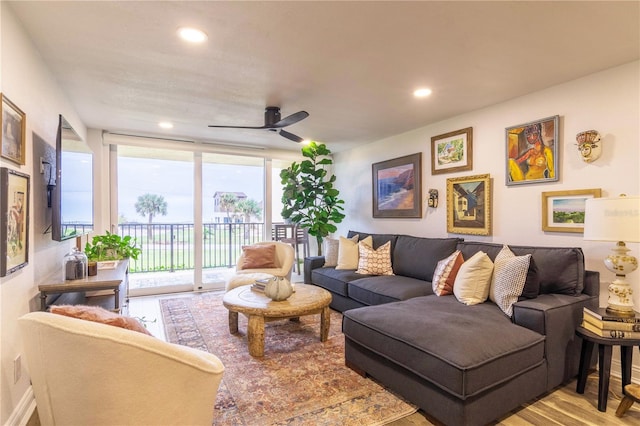 living room featuring ceiling fan, floor to ceiling windows, and light hardwood / wood-style flooring