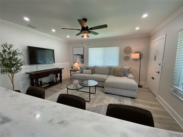 living room featuring ceiling fan, light hardwood / wood-style flooring, and ornamental molding