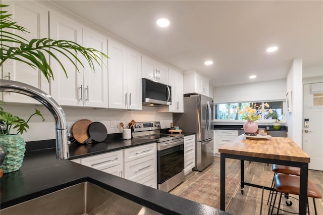 kitchen featuring white cabinetry, stainless steel appliances, and light hardwood / wood-style flooring