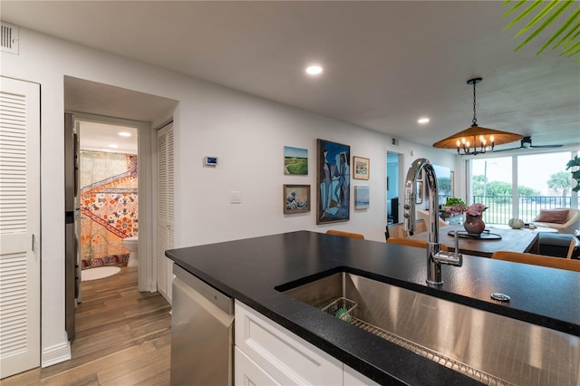 kitchen featuring dishwasher, a notable chandelier, decorative light fixtures, white cabinets, and light wood-type flooring