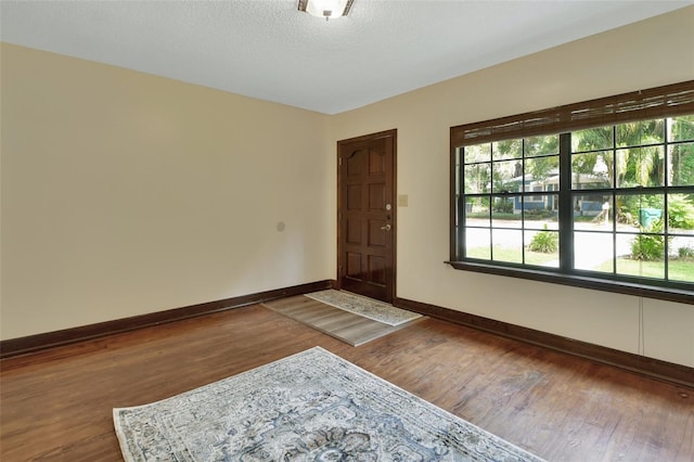 unfurnished room featuring a textured ceiling and dark wood-type flooring