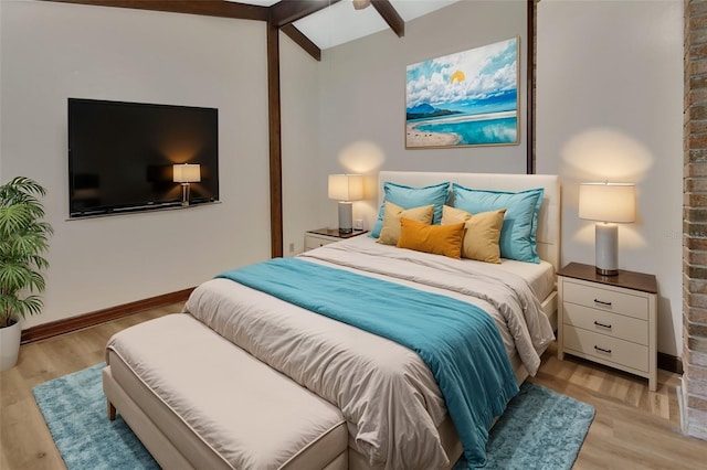 bedroom featuring lofted ceiling with beams, light hardwood / wood-style floors, and ceiling fan