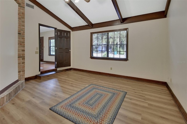 foyer entrance featuring vaulted ceiling with beams and light hardwood / wood-style floors