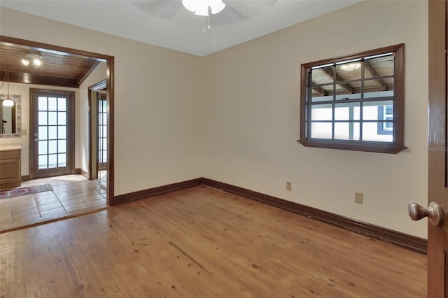 unfurnished room with ceiling fan, light wood-type flooring, and wood ceiling