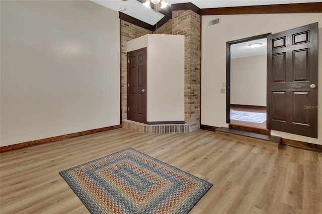 spare room with vaulted ceiling with beams and light hardwood / wood-style floors