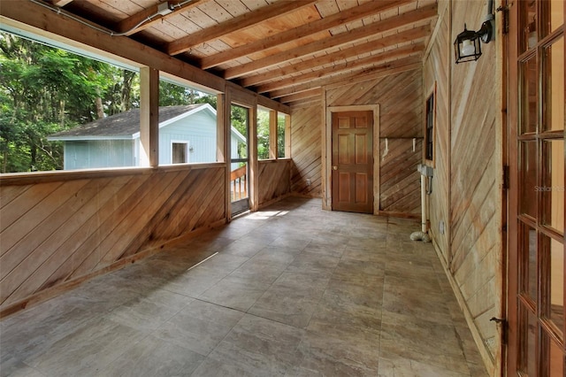 unfurnished sunroom with vaulted ceiling with beams and wooden ceiling