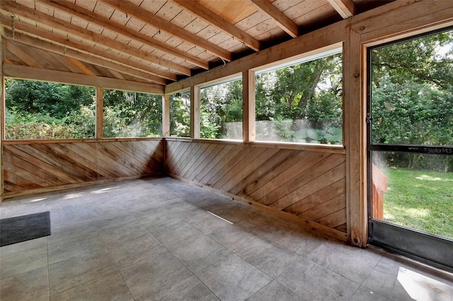 unfurnished sunroom featuring lofted ceiling with beams and wooden ceiling