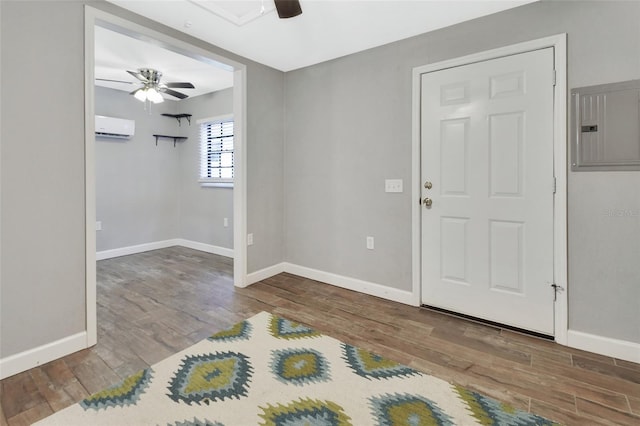 foyer entrance featuring ceiling fan, wood-type flooring, an AC wall unit, and electric panel