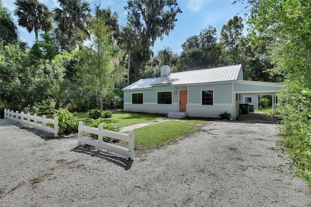 ranch-style home featuring a front lawn and a carport