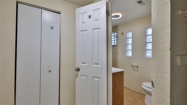 bathroom with tile patterned flooring, vanity, and toilet