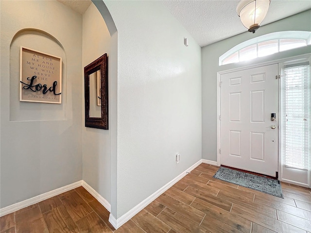 foyer entrance with a textured ceiling