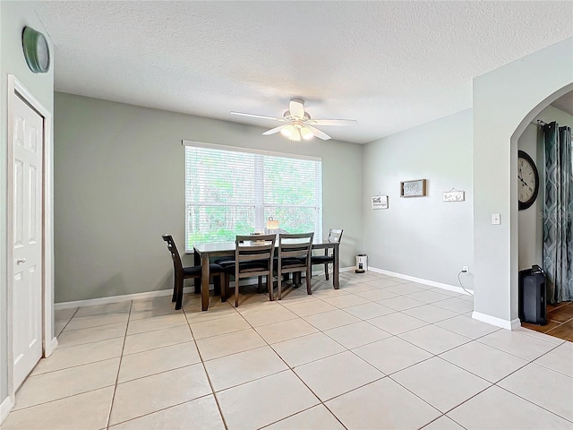 tiled dining area featuring a textured ceiling and ceiling fan