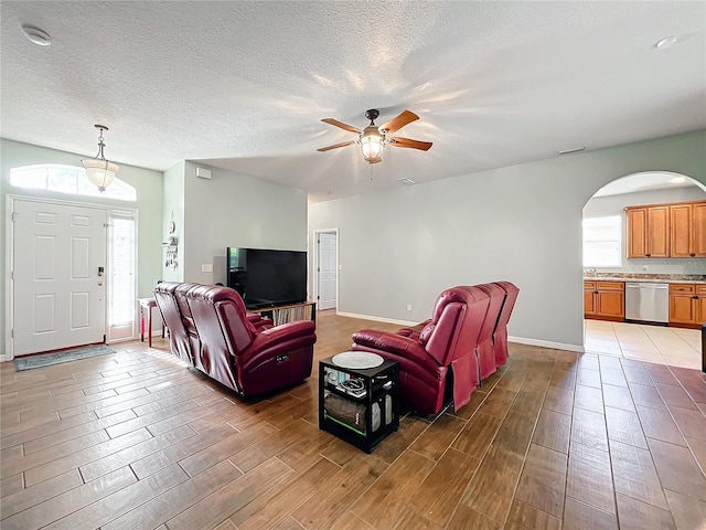 living room featuring ceiling fan, sink, and a textured ceiling