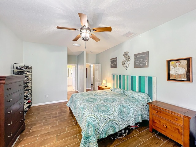 bedroom featuring ceiling fan, a textured ceiling, and ensuite bath