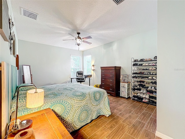 bedroom featuring ceiling fan and a textured ceiling