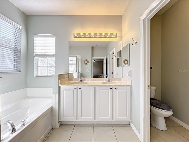 bathroom with tile patterned flooring, vanity, toilet, and a tub