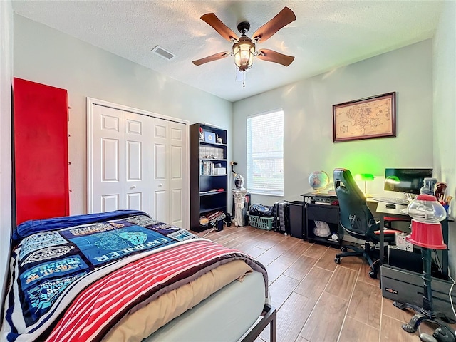 bedroom with ceiling fan, a textured ceiling, and a closet