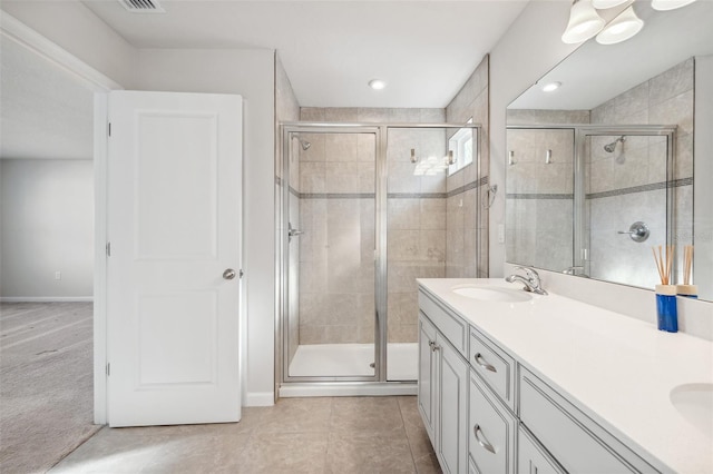 bathroom with tile patterned flooring, vanity, and a shower with shower door