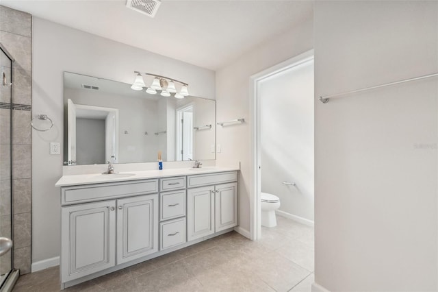 bathroom featuring tile patterned flooring, vanity, toilet, and walk in shower