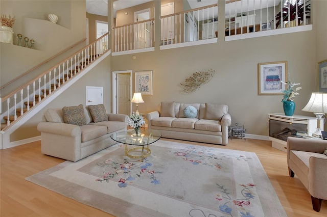 living room featuring wood-type flooring and a high ceiling