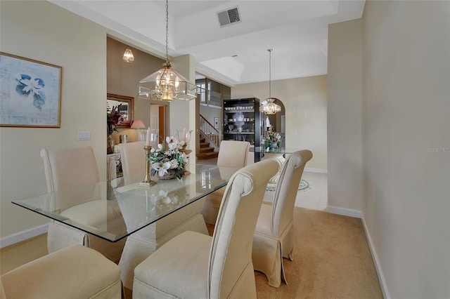 carpeted dining space featuring an inviting chandelier and a raised ceiling