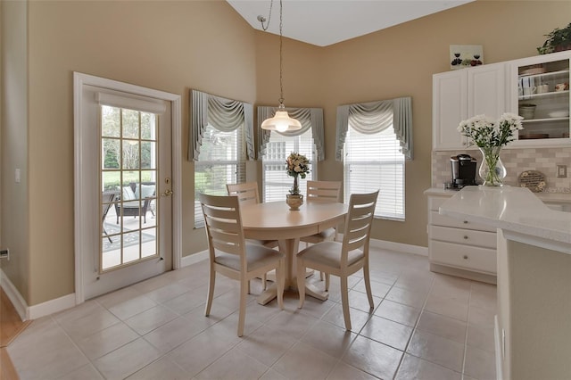 tiled dining area with plenty of natural light and vaulted ceiling