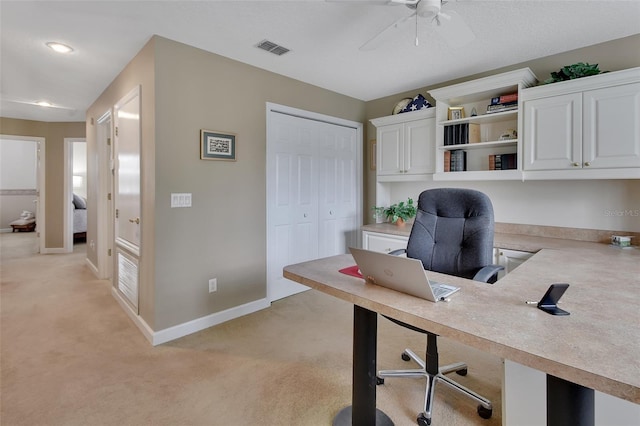 home office with ceiling fan and light carpet