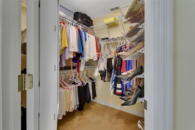 walk in closet featuring light carpet