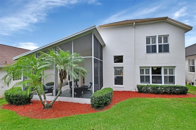 back of property with a sunroom and a yard