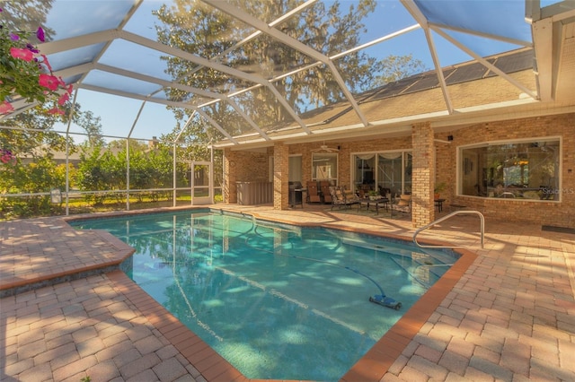 view of pool with ceiling fan, a patio, and glass enclosure