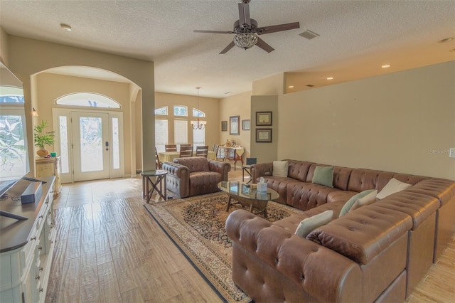 living room featuring ceiling fan, a textured ceiling, and light hardwood / wood-style flooring