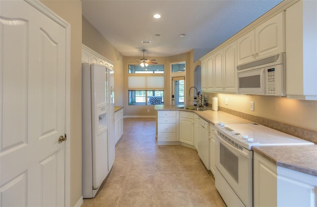 kitchen with ceiling fan, sink, kitchen peninsula, white appliances, and light tile patterned floors